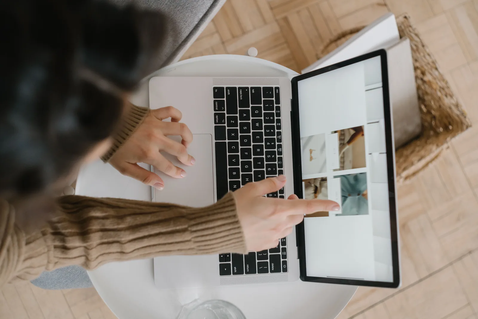 Top view of a woman pointing at laptop screen while browsing photos indoors, showcasing modern digital lifestyle. How to Assess Beefree and Stripo Email Libraries
