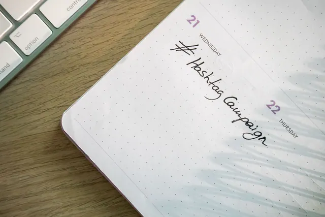 Open planner with 'Hashtag Campaign' handwritten next to keyboard. Ideal for social media and productivity themes. Content Calendar Templates: 2027 Business Guide