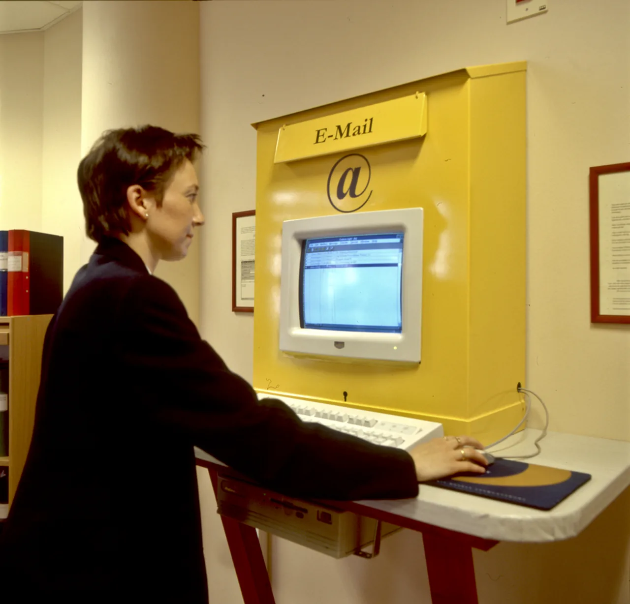 A woman using a computer at a yellow email station in Lund, Sweden, in 1998.